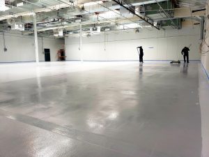 Warehouse with gray epoxy flooring being installed