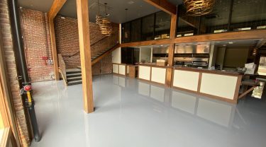 restuarant interior-smooth gray epoxy flooring with high wood beams